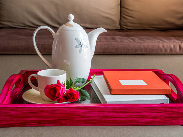 Tea, roses, and books on a red wood tray stock photo
