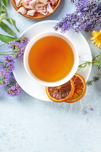 Tea with dry fruit and flowers, shot from the top with a place for text. Lavender, orange, thyme, and other ingredients