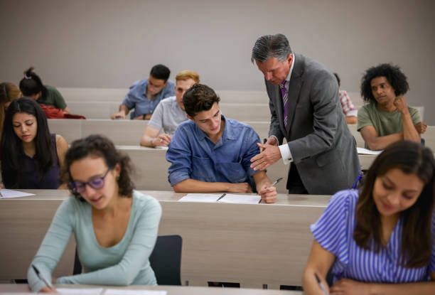 Teacher talking to a student in class stock photo