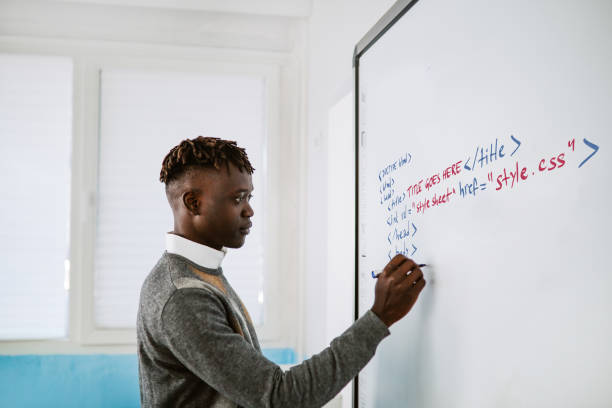 IT teacher writing on the whiteboard in the classroom stock photo