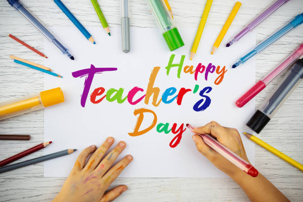 Little child is drawing on paper about teachers day. Happy Teachers Day