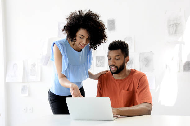 Teaching and learning laptop afro couple stock photo