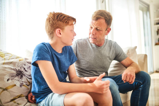Teaching him valuable lessons about life Shot of a mature father and his son having a disagreement at home punishment stock pictures, royalty-free photos & images
