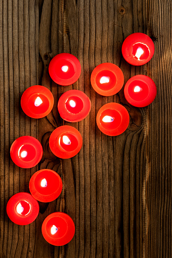 Red candles on wood background.