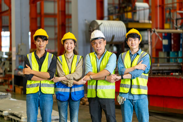 Team of Asian engineer workers holding hand together for strong cooperation and team building inside the steel manufacturing factory for trust and partnership agreement concept stock photo
