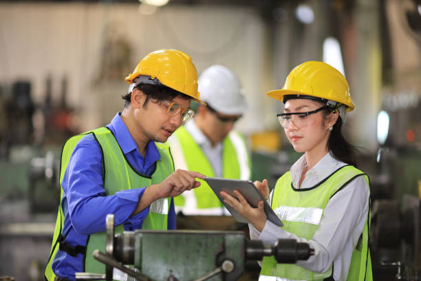 Team of engineer in full safety equipment is working and inspecting the heavy industrial factory concept stock photo