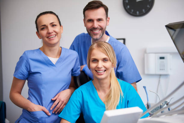 team glücklicher stomatologen in zahnarztpraxis - zahnpflege fotos stock-fotos und bilder