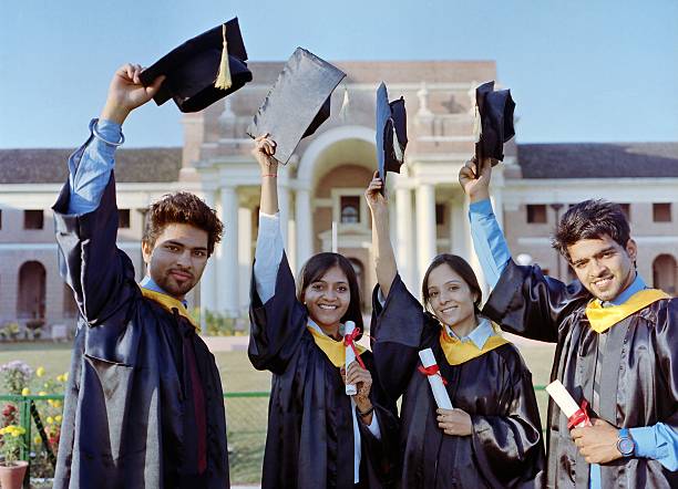 Team of successful university graduates raising their convocation caps. Happy group of Indian college students with arms up at their graduation ceremony. hats off to you stock pictures, royalty-free photos & images