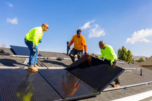 Team of Workers Installing Solar Panels on Residential Rooftop in California stock photo