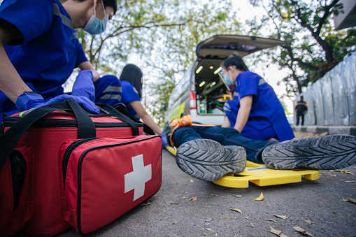 Selective focus is first aid bag. Team paramedic firs aid accident on road. Ambulance emergency service. First aid procedure.
