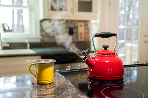 Teapot on stove top blowing steam