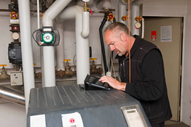 Technician checking an old oil heating system stock photo