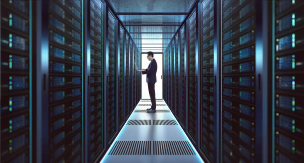 IT Technician in suit works on laptop IT Technician in suit works on laptop working in server room . data center stock pictures, royalty-free photos & images