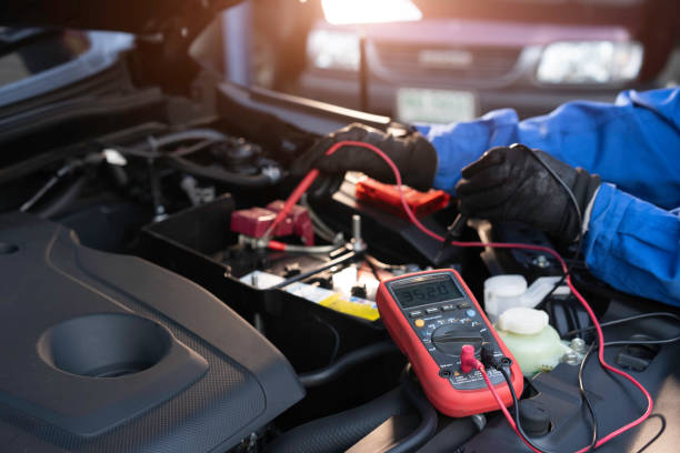 technician measure voltage of battery in the car at service station Asian technician measure voltage of battery in the car at service station, Maintenance and repair battery charger stock pictures, royalty-free photos & images