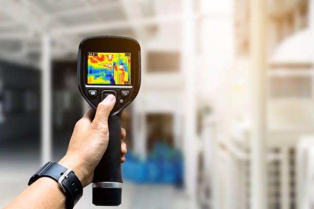 Technician use thermal imaging camera to check temperature in factory stock photo