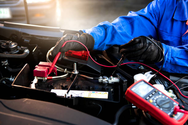 Technician uses multimeter voltmeter to check voltage level in car battery. Service and Maintenance car battery. stock photo