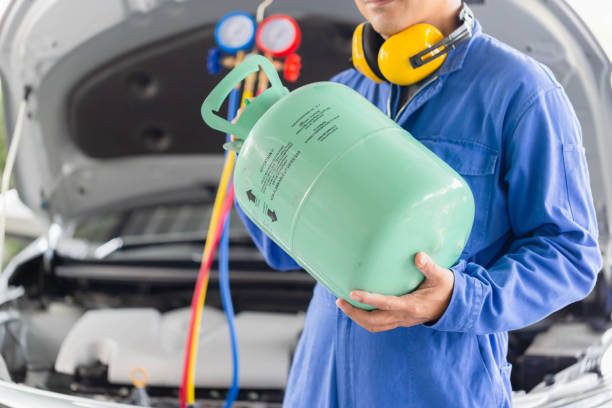 Technician with manifold tool gauge bucket refrigerant applies to car air conditioning, Repairman holding monitor tool to check and fixed car air conditioner system, Air Conditioning Repair stock photo