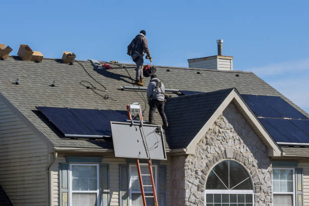 Technician workers installing alternative energy photovoltaic solar panels on roof stock photo