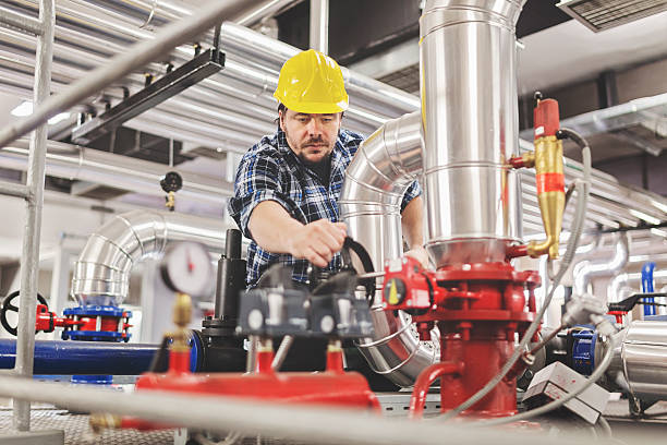 Technician working on valve in factory or utility stock photo