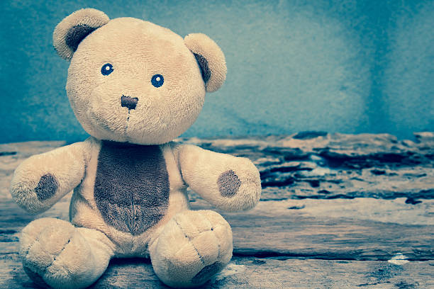 Teddy bear sitting on old wood background