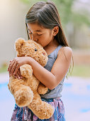 Cropped shot of a little girl kissing her teddy bear