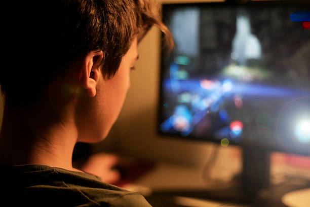 Teenage boy addicted to video games stock photo