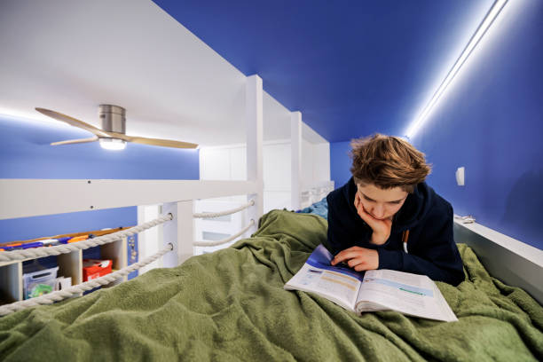 adolescente acostado en la cama y estudiando para la escuela - bunk beds fotografías e imágenes de stock