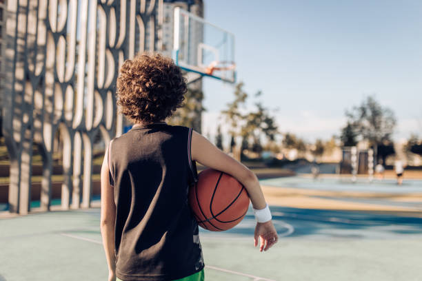 tiener die zich op de basketbalbinnenplaats bevindt - basketball player back stockfoto's en -beelden