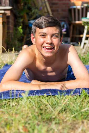 Teenage Boy Sunbathing In The Garden Stock Photo 