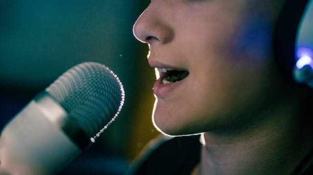Teenage Boy Talking Into a Microphone at Night stock photo