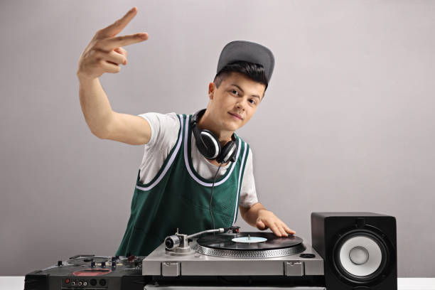 Teenage DJ making a peace sign Teenage DJ making a peace sign against a gray wall club dj stock pictures, royalty-free photos & images
