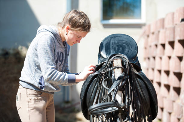tonårig flicka equestrian rengör svart läder häst sadel - clean saddle bildbanksfoton och bilder