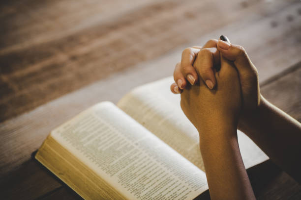 teenage girl hand with Bible praying in the morning stock photo