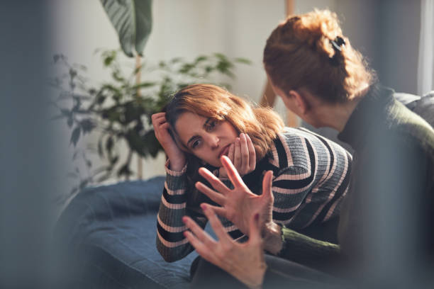 Teenage girl in difficult mood with angry mom. stock photo