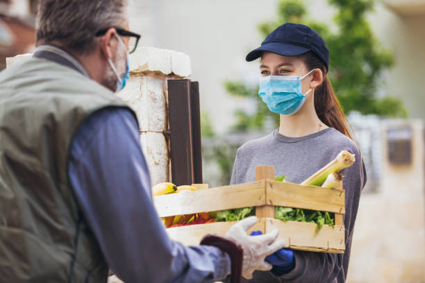 Teenage girl is delivering some groceries to an elderly person, during the epidemic coronovirus, COVID-19. Teenage girl is delivering some groceries to an elderly person, during the epidemic coronovirus, COVID-19. a helping hand stock pictures, royalty-free photos & images
