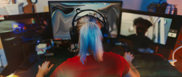 Teenage Girl Playing Multiplayer Games on Desktop Pc in his Dark Room stock photo