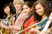 Teenage girl playing saxophone in band
