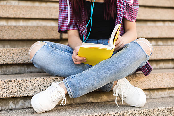 Teenage girl reading a book - close-up stock photo