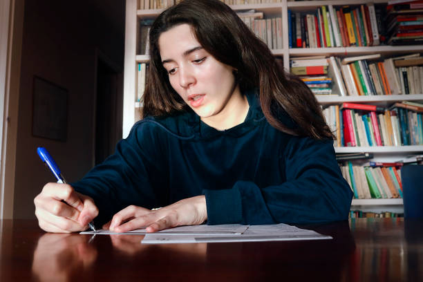 teenage girl studying in the library stock photo