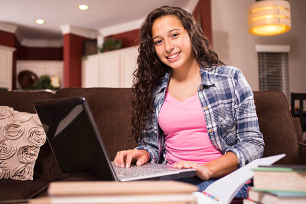 Teenage girl studying or doing homework at home stock photo