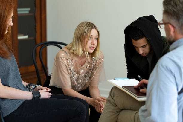Teenage girl talking with psychologist during meeting of support group Teenage girl talking with psychologist during meeting of support group drug rehab stock pictures, royalty-free photos & images