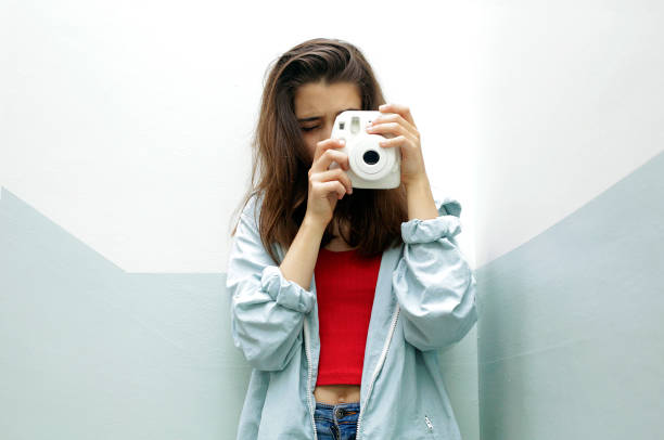 Teenage girl with a instant print camera stock photo