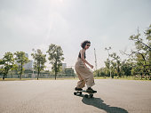 istock Teenage girl with skateboard in the park on a sunny day. 1300510279