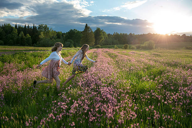 Teenage girls running in a field. stock photo