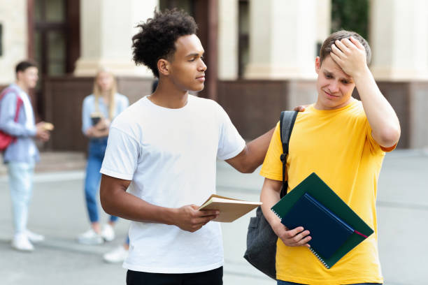 Teenage guy consoling friend over bad exam result Failed test. Teenage guy consoling friend over bad exam result outdoors students exam results stock pictures, royalty-free photos & images