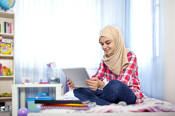 teenage muslim girl using tablet computer - arabic student stockfoto's en -beelden