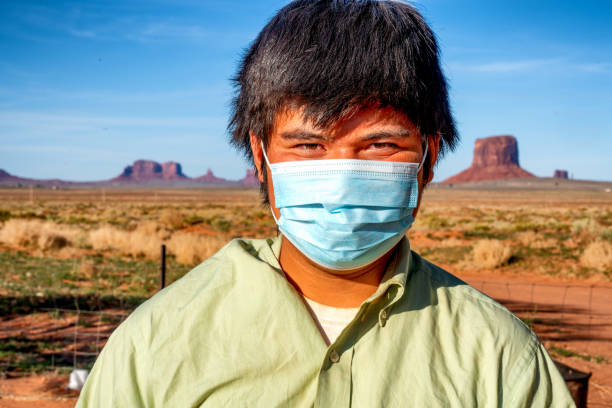 Teenage Navajo Boy Posing in Monument Valley Wearing a Covid-19 Mask to help prevent the spread of the Coronavirus Teenage Navajo Boy Posing in Monument Valley Wearing a Covid-19 Mask to help prevent the spread of the Coronavirus navajo nation covid stock pictures, royalty-free photos & images