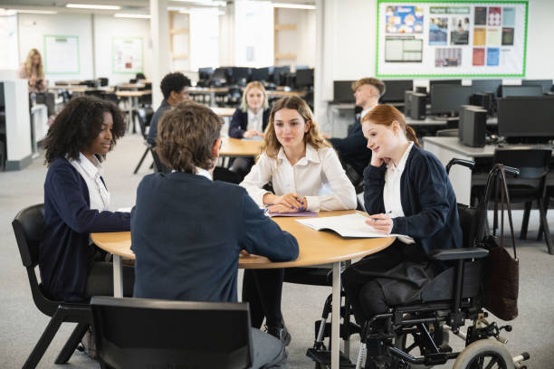 Teenage students interacting in collaborative workspace stock photo