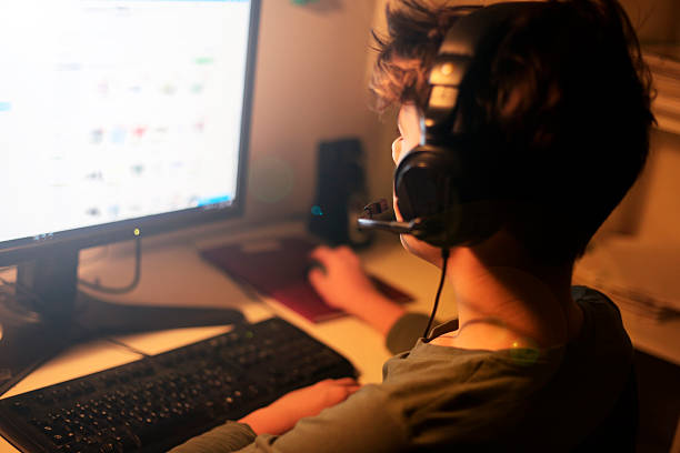 Teenage YouTuber with headphones using the computer stock photo