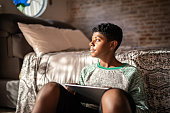 istock Teenager boy using digital tablet and contemplating at home 1331827264